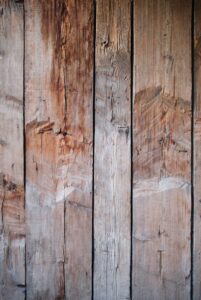 Hand applying sealant to freshly pressure-washed wooden deck with proper technique